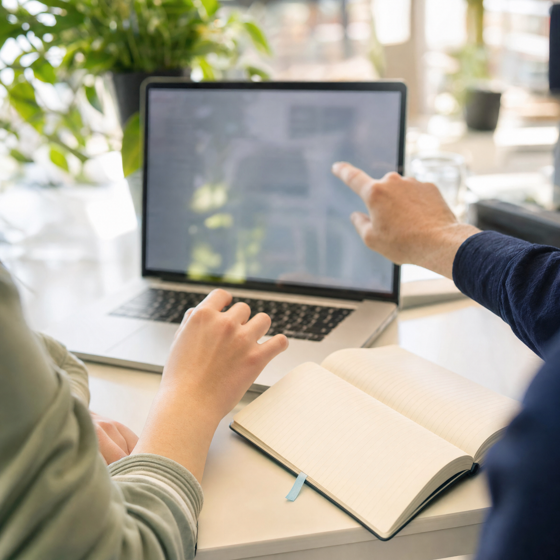 Student en mentor werken samen achter een laptop
